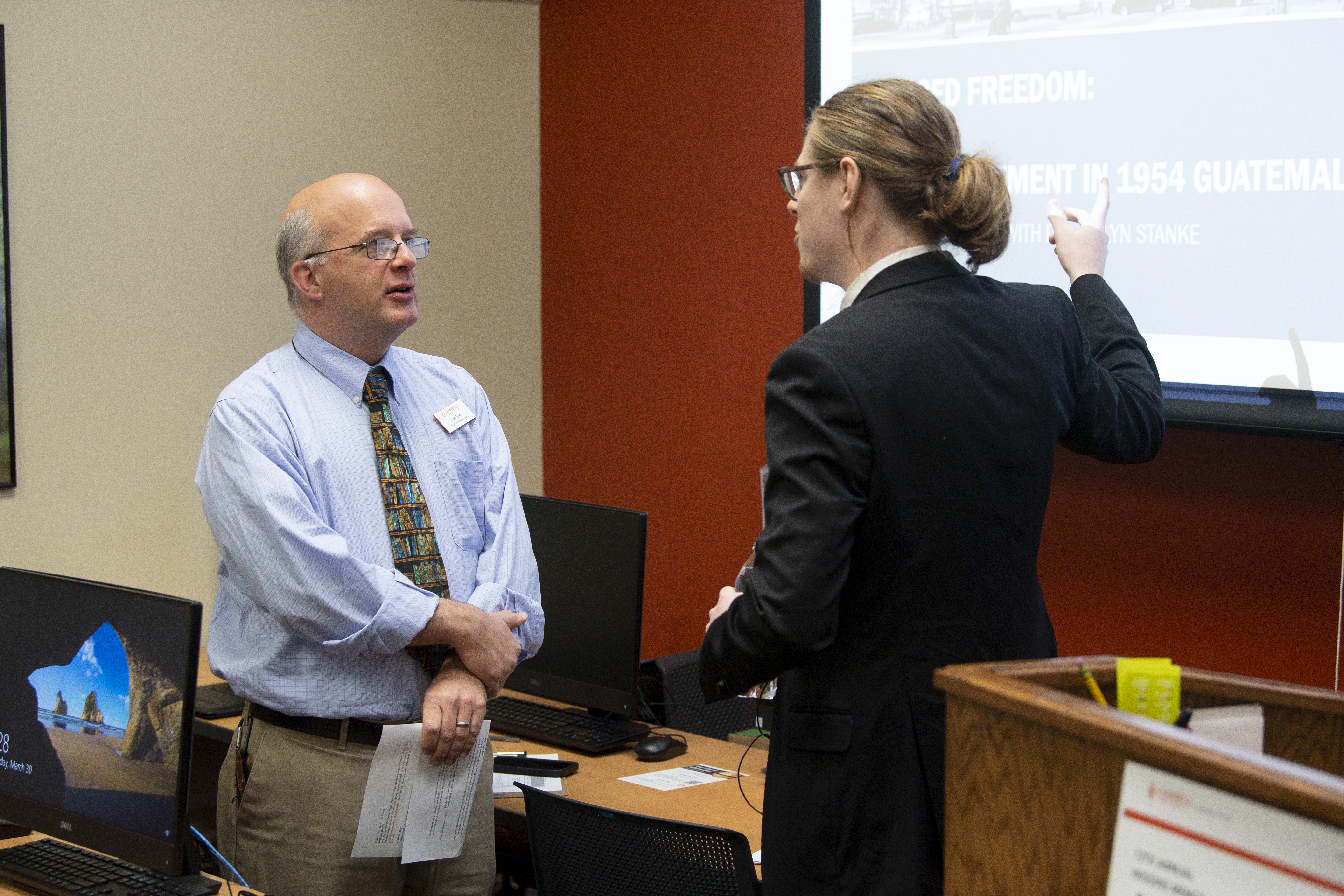 Symposium presenter addresses librarian after an oral presentation