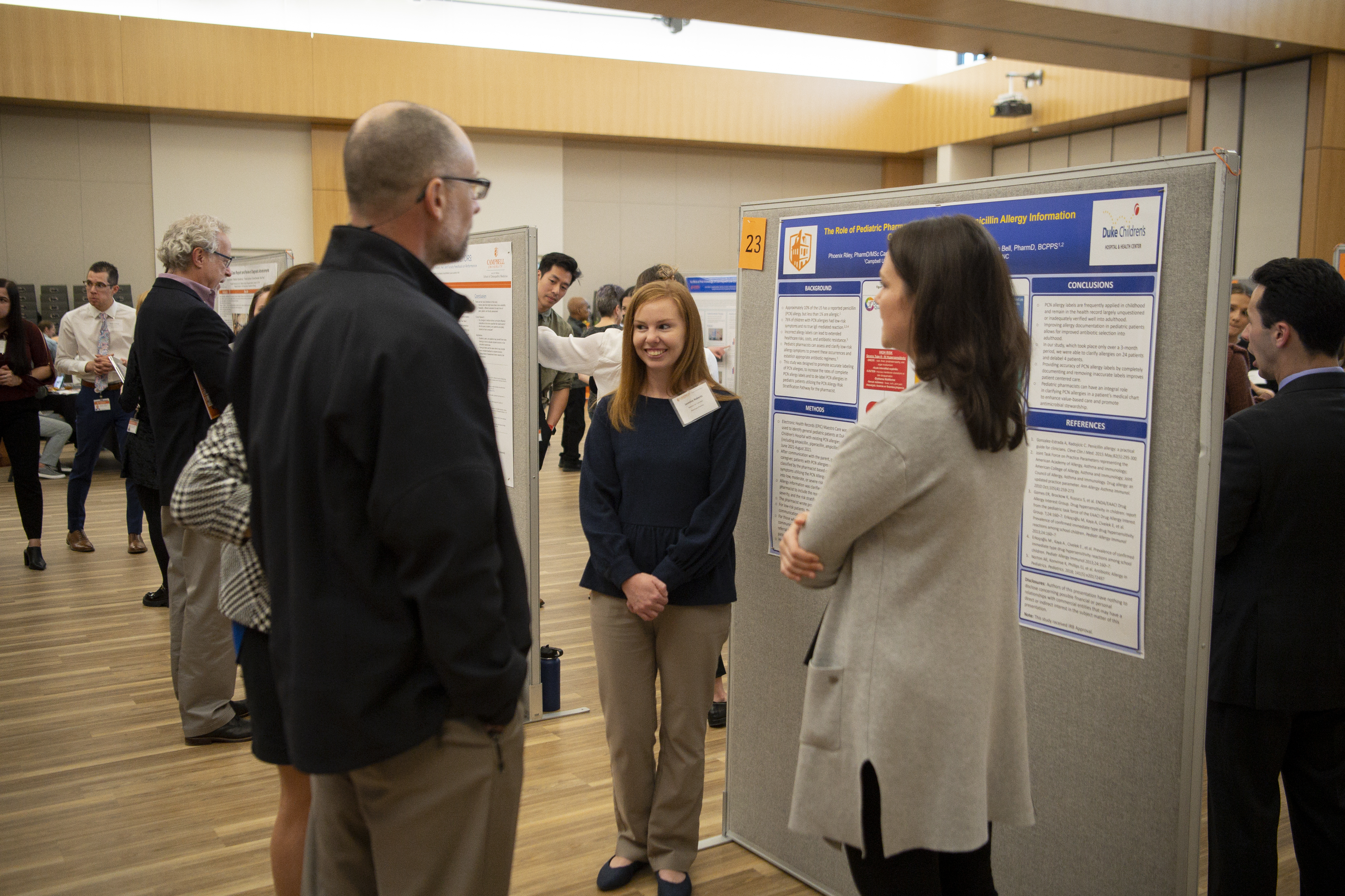 Student presents poster to a group